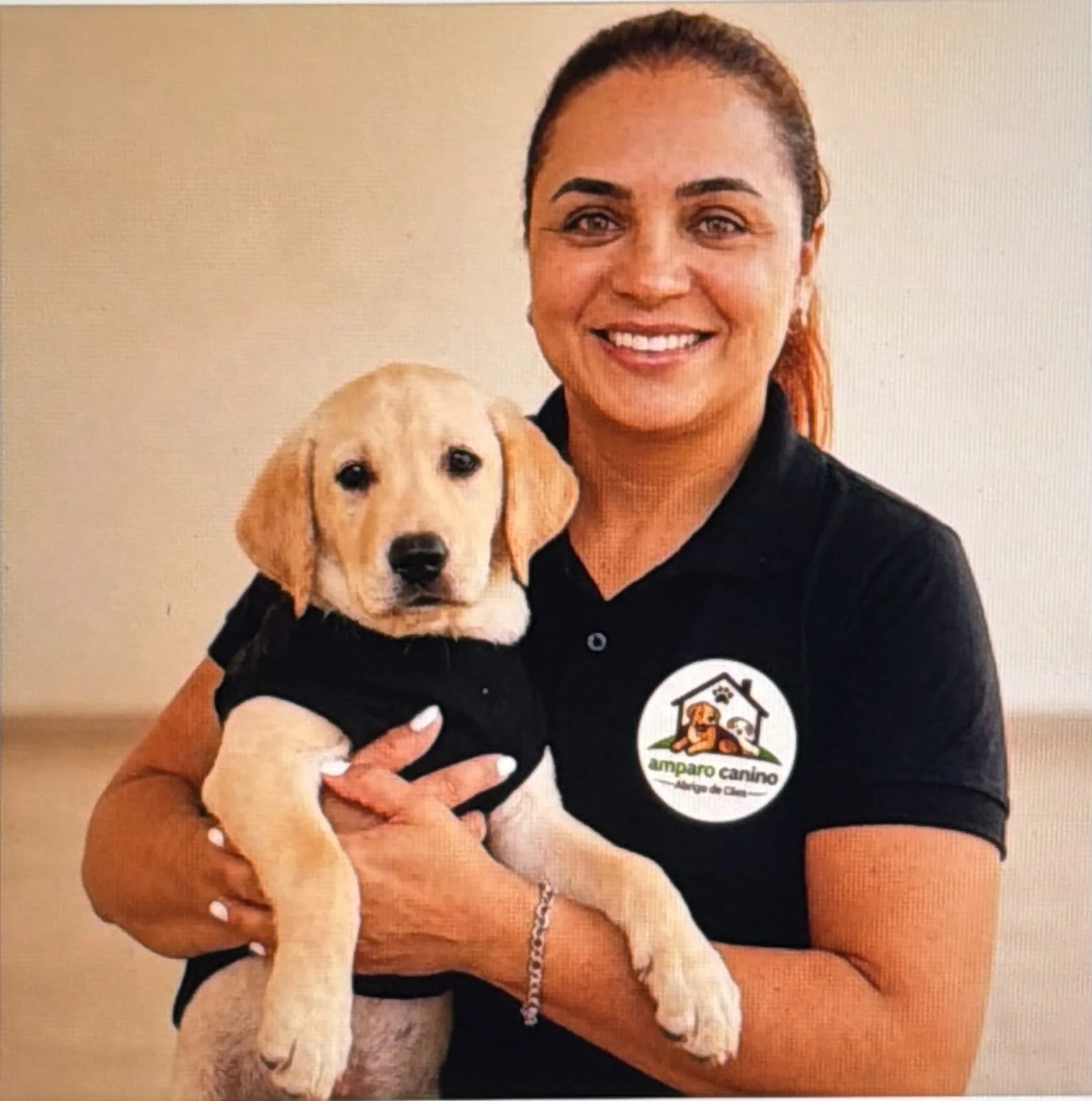 Antonia Mayara, responsável pelo Amparo Canino, segurando um filhote de labrador